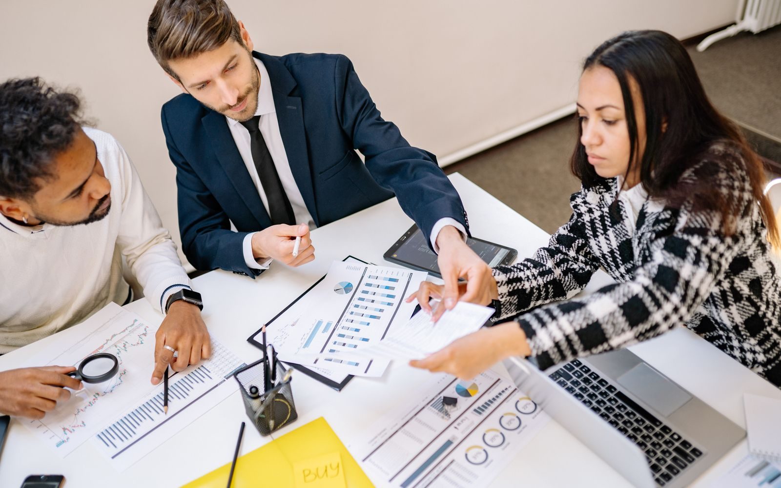 Small professional team reviewing project plans on a screen in a bright office